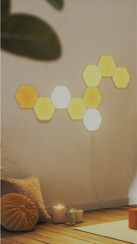 Cette image montre une disposition de 9 panneaux Hexagones Nanoleaf Shapes dans une salle de méditation. Les lumières RVB sont idoines pour se détendre ou trouver l’inspiration.