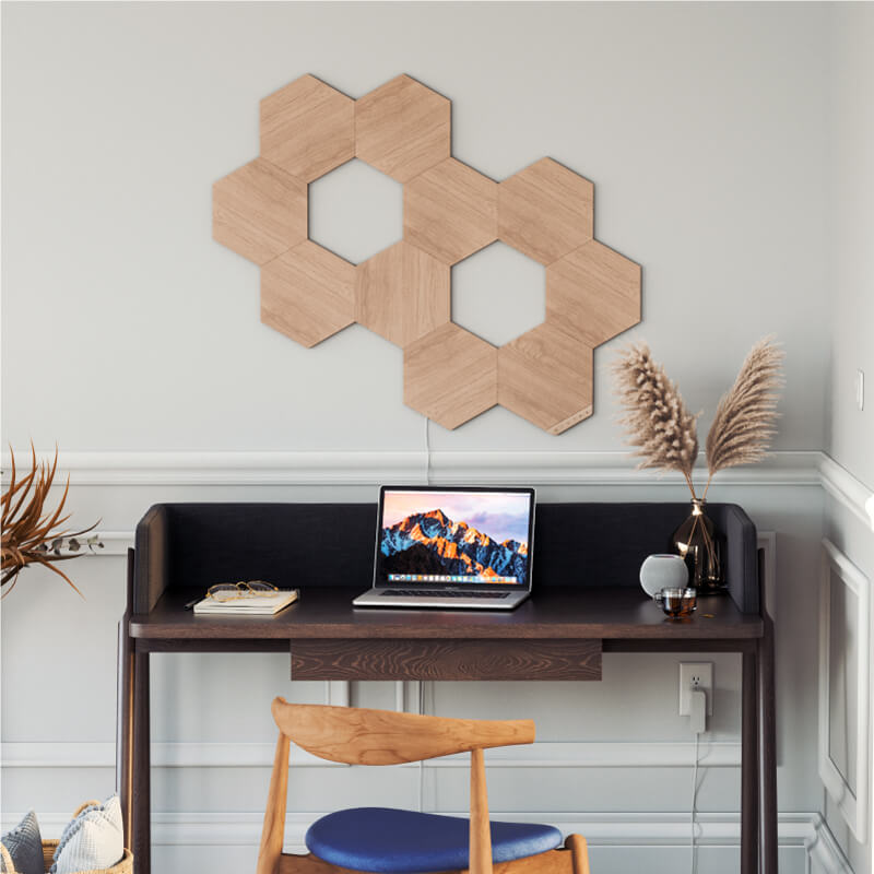 Panneaux lumineux modulaires intelligents Hexagones effet bois et fil compatible Nanoleaf Elements sur un mur de bureau à domicile. HomeKit, Google Assistant, Amazon Alexa, IFTTT.