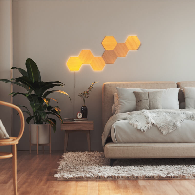 Panneaux lumineux modulaires intelligents Hexagones effet bois et fil compatible Nanoleaf Elements, montés sur un mur de chambre à coucher. HomeKit, Google Assistant, Amazon Alexa, IFTTT.
