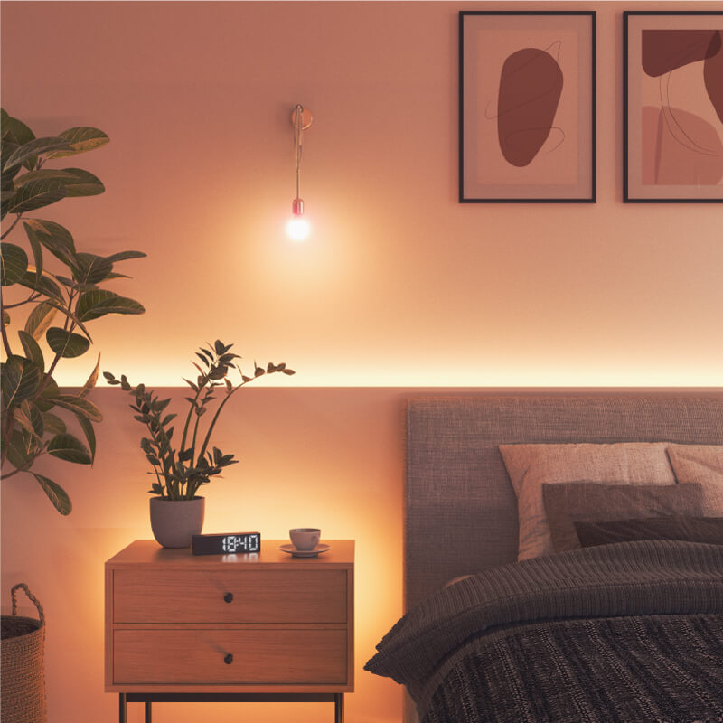 Ampoule intelligente aux couleurs changeantes et fil compatible Nanoleaf Essentials, montée sur un luminaire dans une chambre à coucher. Produit semblable à Wyze. HomeKit, Google Assistant, Amazon Alexa, IFTTT.