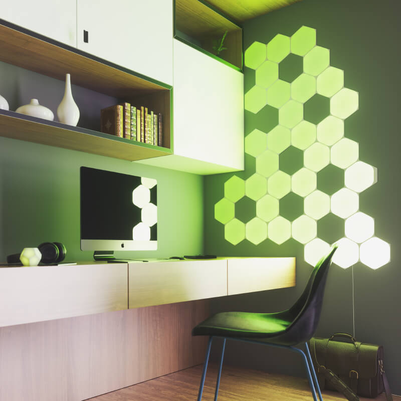 Panneaux lumineux modulaires intelligents Hexagones aux couleurs changeantes et fil compatible Nanoleaf Shapes, montés sur un mur de bureau à domicile. Produit semblable à Philips Hue, Lifx. HomeKit, Google Assistant, Amazon Alexa, IFTTT.