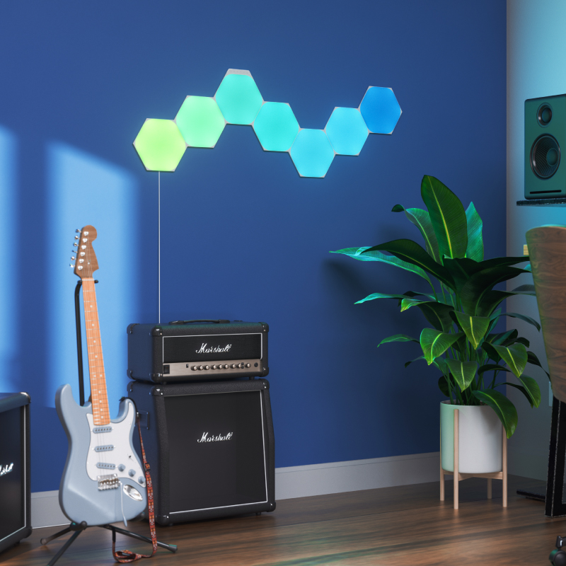 Panneaux lumineux modulaires intelligents Hexagones aux couleurs changeantes et fil compatible Nanoleaf Shapes, montés sur un mur dans une salle de musique. Produit semblable à Philips Hue, Lifx. HomeKit, Google Assistant, Amazon Alexa, IFTTT.