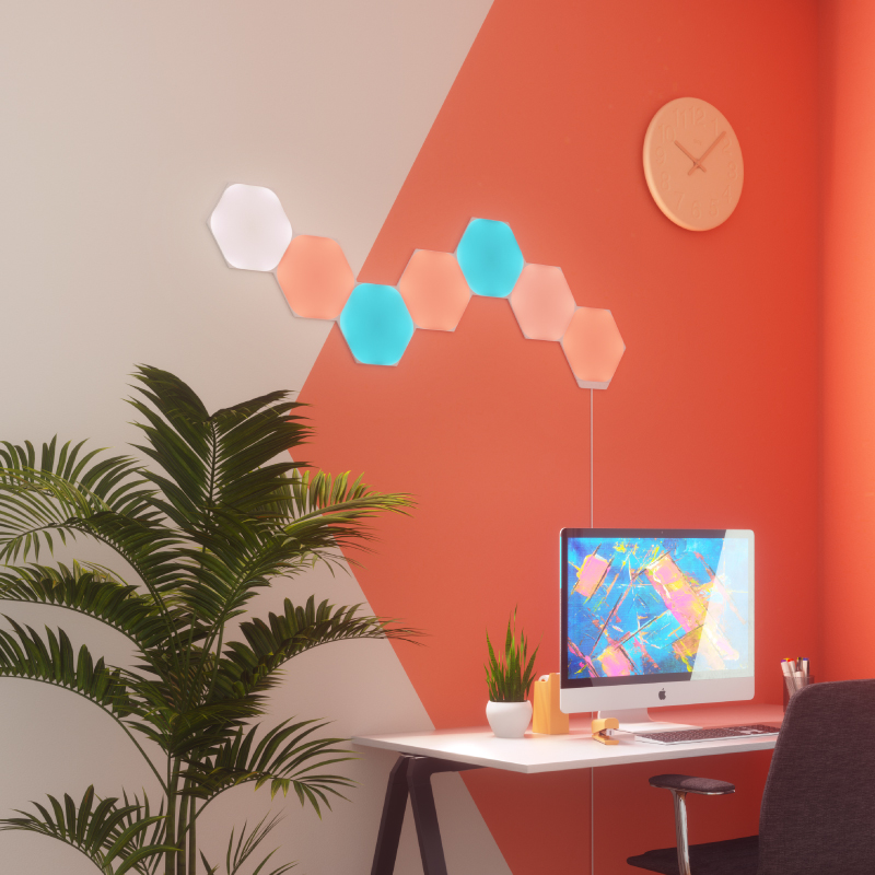 Panneaux lumineux modulaires intelligents Hexagones aux couleurs changeantes et fil compatible Nanoleaf Shapes, montés sur un mur de bureau à domicile. Produit semblable à Philips Hue, Lifx. HomeKit, Google Assistant, Amazon Alexa, IFTTT.