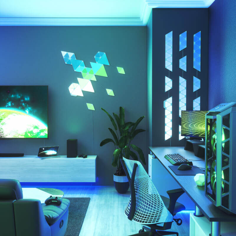 Nanoleaf Shapes Thread-enabled color-changing mini triangle smart modular light panels mounted to a wall above a battlestation. Similar to Philips Hue, Lifx. HomeKit, Google Assistant, Amazon Alexa, IFTTT. 
