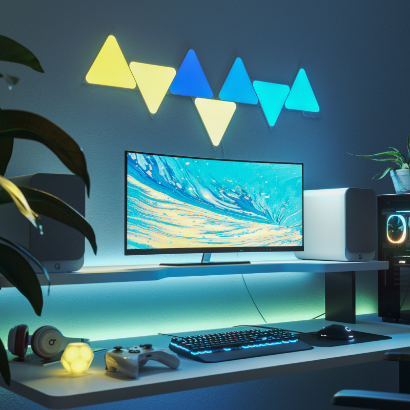 Nanoleaf Shapes Thread enabled color changing triangle smart modular light panels mounted to a wall above a battlestation. Similar to Philips Hue, Lifx. HomeKit, Google Assistant, Amazon Alexa, IFTTT.