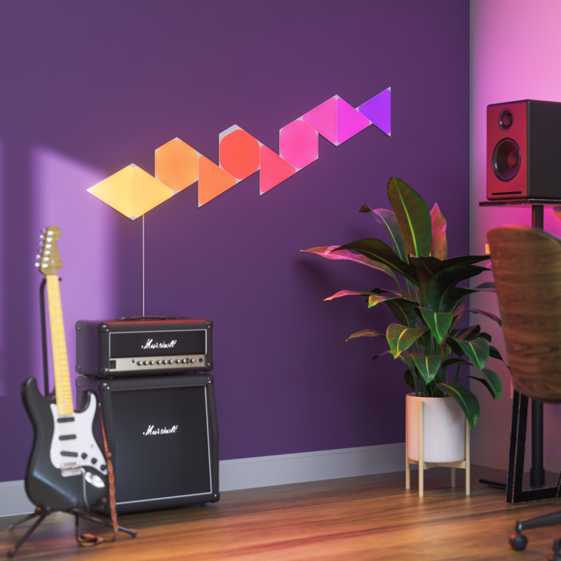 Panneaux lumineux modulaires intelligents Triangles aux couleurs changeantes et fil compatible Nanoleaf Shapes, montés sur un mur dans une salle de musique. Produit semblable à Philips Hue, Lifx. HomeKit, Google Assistant, Amazon Alexa, IFTTT.